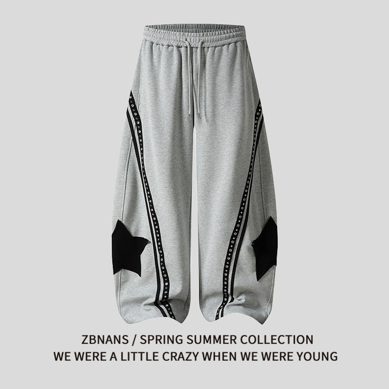 Gray sweatpants with black star designs on a light gray background, featuring text about a spring summer collection.